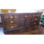George III oak and cross banded dresser base enclosing 7 drawers and 2 drawer cupboard 211cm wide