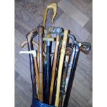 A collection of walking sticks, some with silver mounts, one containing a ruler within, also a