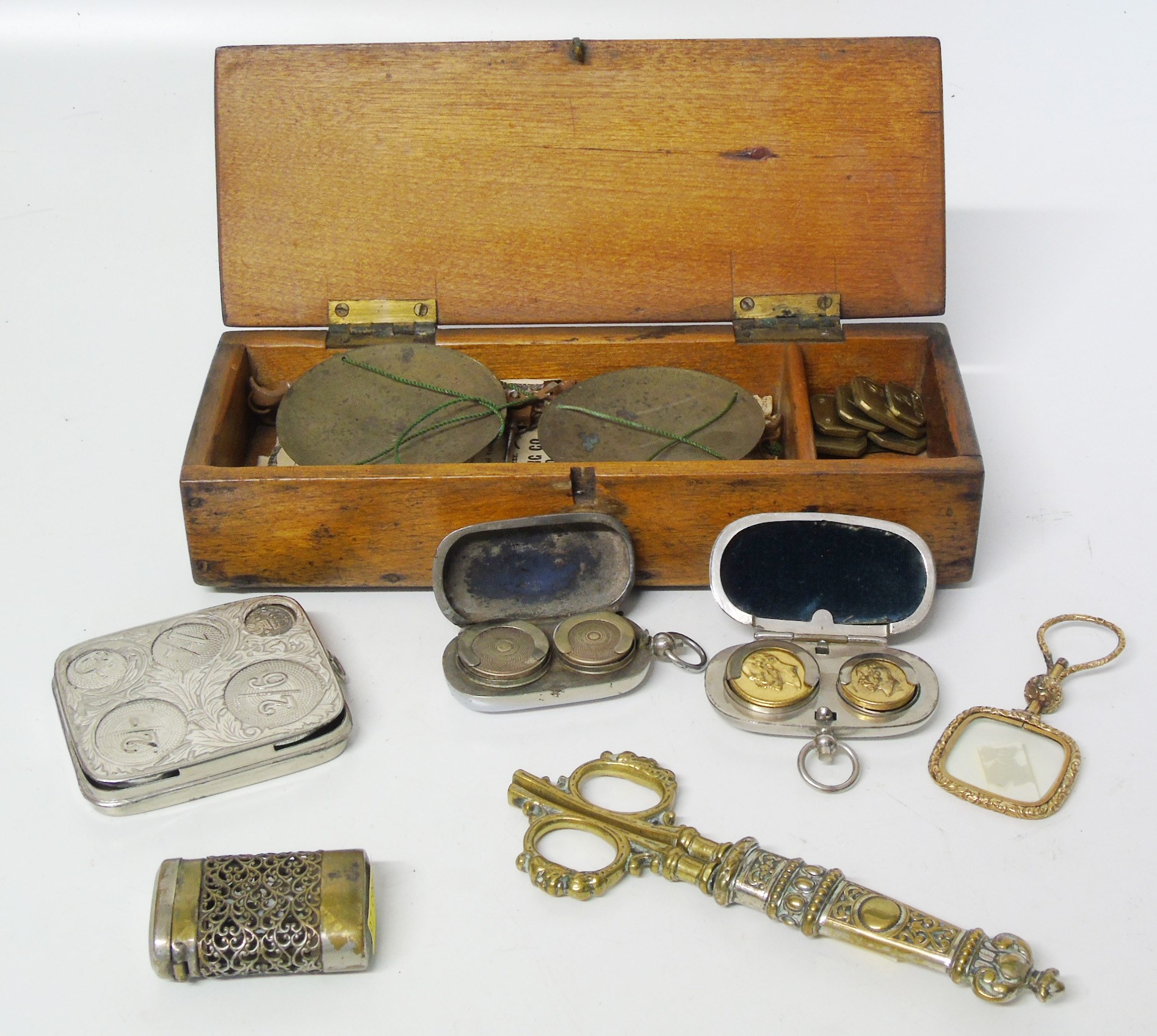 A set of portable balance scales, brass travel scissors, plated coin case and other decorative