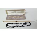 A jet bead necklace, a pearl necklace with 9ct gold clasp and a three-strand pearl necklace with