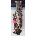 A large assortment of costume jewellery necklaces on wooden jewellery tree Condition reports are not