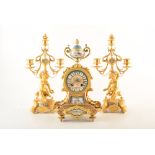 A 19th century French ormolu mantel clock and garnitures. Topped with painted ceramic loving cup,