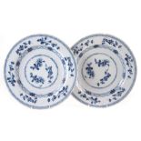 Pair of Delft chargers, painted with flowers in the style of Chinese export porcelain, in under