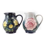 Two Moorcroft jugs, one decorated with buttercup pattern the other with Rose pattern after Sally