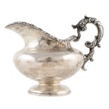 A George III silver milk jug , plain polished baluster form body with gilt interior, acanthus scroll