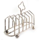 A silver toast rack by Mappin and Webb , plain polished body with six divisions on four ball feet,