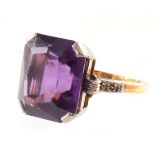 Amethyst single stone 18ct gold ring with diamond set shoulders , the octagonal mixed cut amethyst