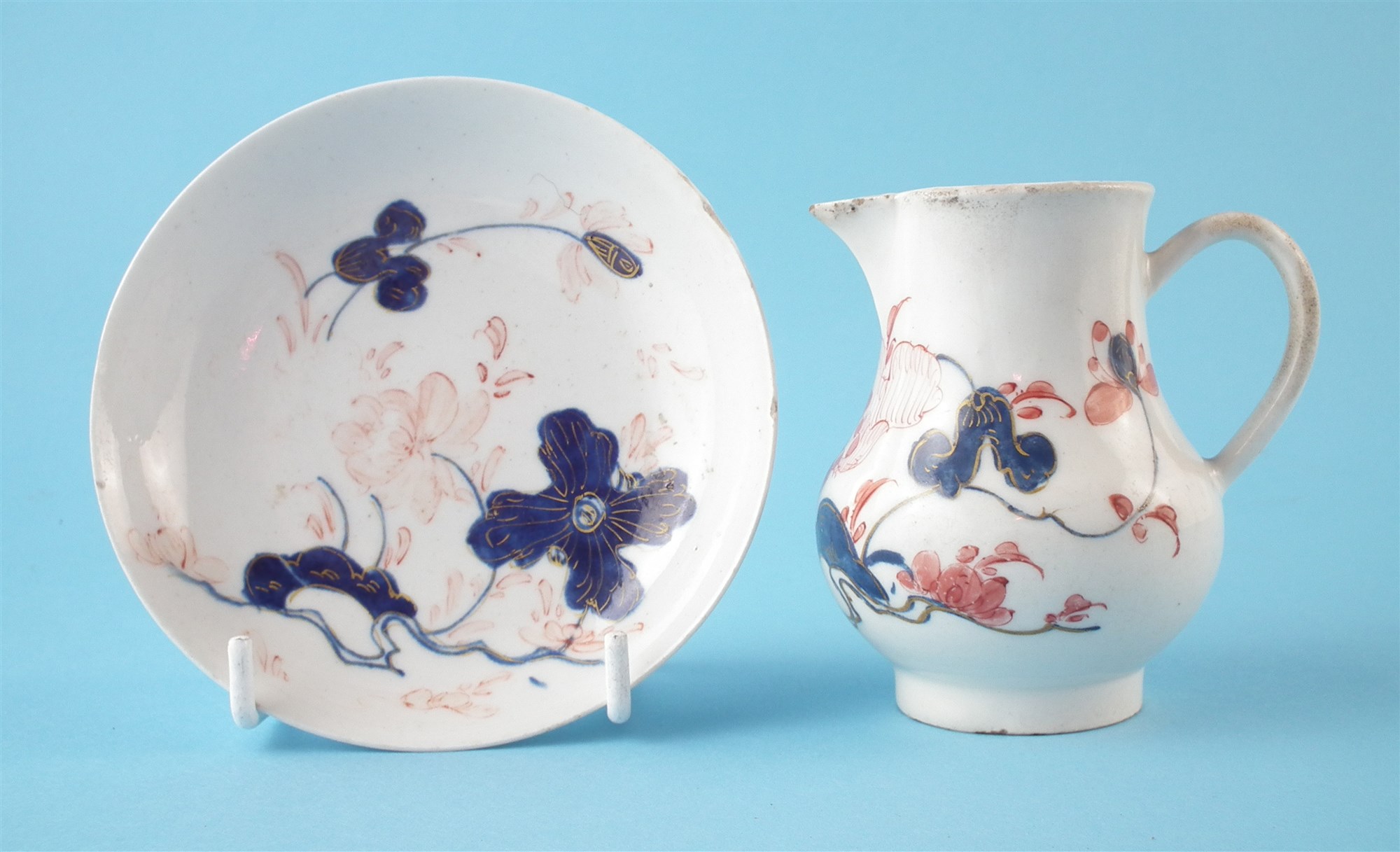 Bow jug and a saucer circa 1755 , painted with flora in an imari palette, both have 'W' marks to