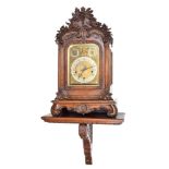 A 19th century German bracket clock with bracket. The oak case has black forest style carving; a