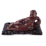 Chinese hardwood reclining Buddha, with pierced sit in wood stand, late 19th early 20th century, the