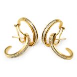 Pair of 18ct gold diamond set curved earrings , the interlocking double c-scroll design channel