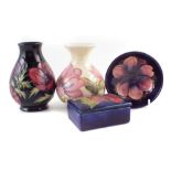 Two Moorcroft vases, small bowl and a box, decorated with Hibiscus, Anemone, and Magnolia,