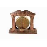 An Arts & Crafts movement copper and brass dinner gong. With hammered copper and etch marks to the