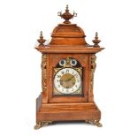 A Victorian walnut bracket clock. The pagoda top has three urn-shaped finials and tiling detail. A