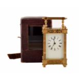 A 20th carriage clock with brass case . Corinthian piers and foliate fretwork frame an enamel dial