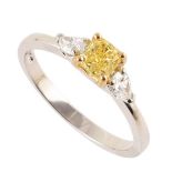 A fancy natural intense yellow diamond and white diamond 3-stone platinum ring , central round
