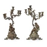 A pair of 19th century bronze candelabra. A male and female figure hold aloft a bower of an acanthus