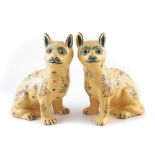 Pair of Faïence pottery cats, painted with flowers on yellow grounds, late 19 th early 20 th