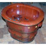 A red lacquered Chinese baby bath on wooden stand, embellished with a foliate design and birds