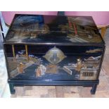 A 20th century laquered Chinese camphor wood chest with painted design of figures outside a temple