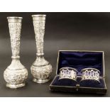 Two Asian silver small vases together with silver plated napkin rings complete with box Conditions