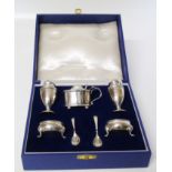 A boxed silver set comprising two salts, two pepperettes, small mustard pot, two silver mustard