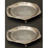 Two matched silver salvers by Harry Atkin, plain polished form with shell and gadroon borders on 3