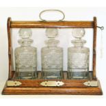 Edwardian oak three bottle tantalus. Condition reports are not available for our Interiors Sale.