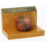 Leather cricket ball on plinth bearing inscription, used in the 4th test match at Melbourne