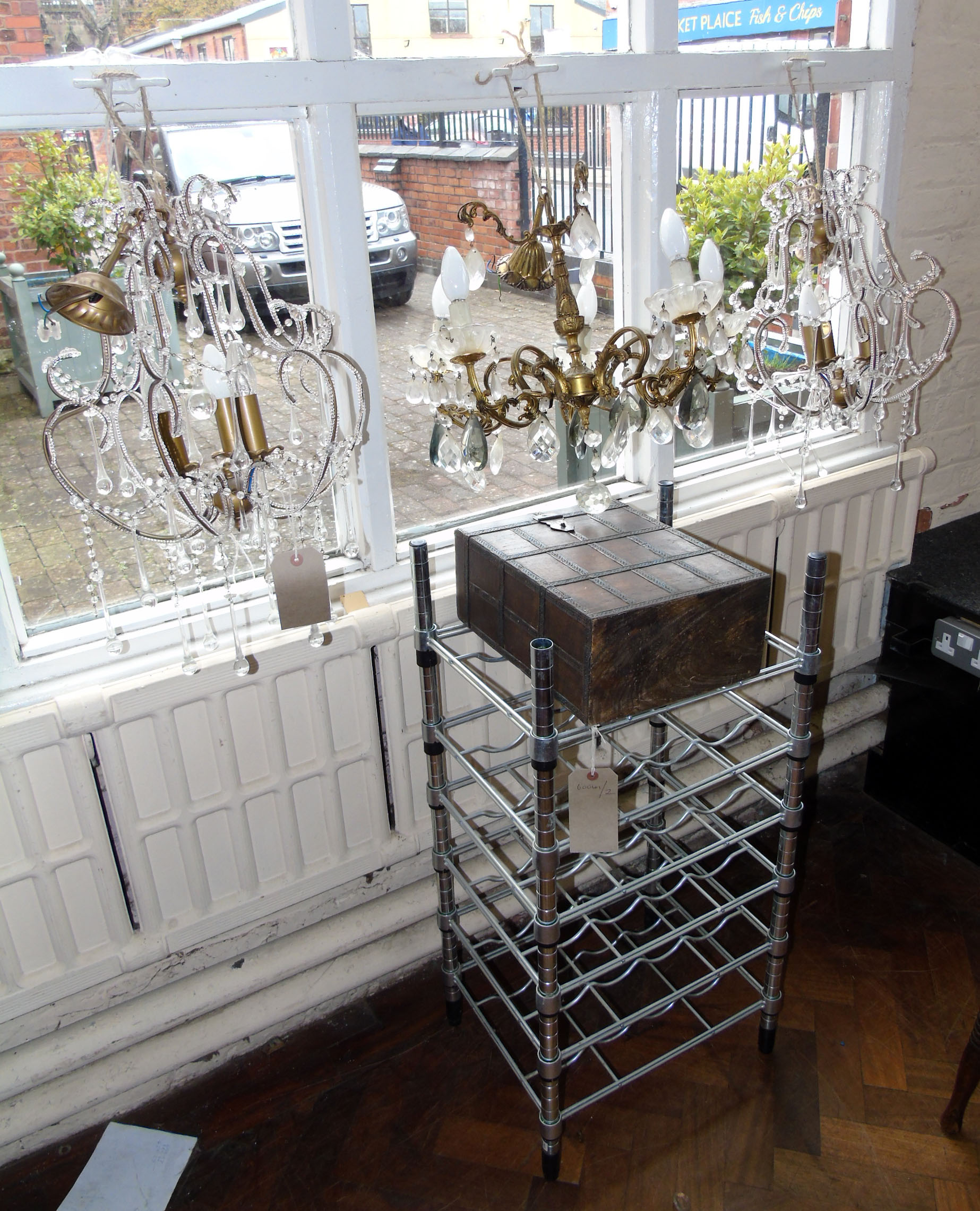 A modern 18 bottle wine rack, two bottle wine container with metal banding and three chandeliers