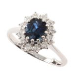 Sapphire and diamond 18ct white gold cluster ring , central oval mixed cut sapphire weighing