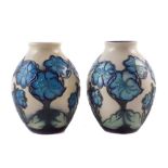 Matched pair of Moorcroft vases, decorated with blue as the sky pattern (2) 13cm high For a