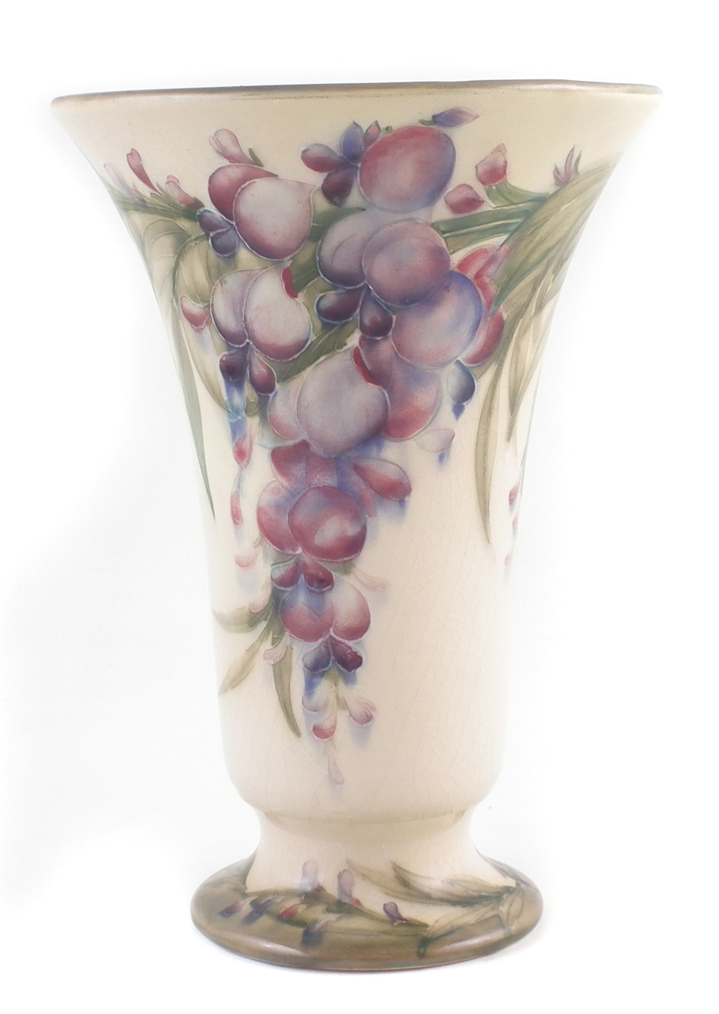 Moorcroft wisteria pattern vase , decorated on a cream coloured back ground with green borders, 22cm
