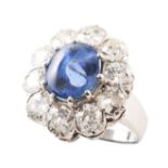 Sapphire and diamond oval cluster ring , central mid-blue oval cabochon sapphire measuring approx.