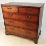 A Georgian mahogany chest of two short over three graduated long drawers, raised on bracket feet,