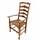 A 19th century ladder back armchair, with rush seat,