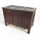 An antique oak coffer, with triple panelled rising lid, having carved triple panelled front,