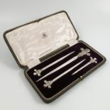 A cased set of four Mappin & Webb silver plated meat skewers, with fleur de lys finials,