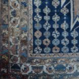 An Oriental rug, decorated a with central lozenge, having shaped spandrels and a multiple border,