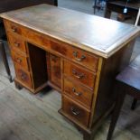 An 18th century style mahogany kneehole desk, having central cupboard door,