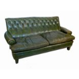 A 20th century leather sofa, with a raked back and tapering front feet,