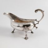 A Georgian silver sauce boat, with scroll handles, gadrooned edge and raised on three scroll feet,