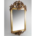 A gilt framed wall mirror, the rectangular bevelled mirror plate having a gilt frame with scrolls,