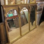 A large gilt mirror, having three arched plates, flanked by barley twist columns.