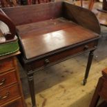 A 19th century mahogany washstand, with rising lid, opening to reveal aperture for washbowl,