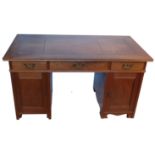 A 20th century kneehole desk, fitted with three frieze drawers and a cupboard to each side,