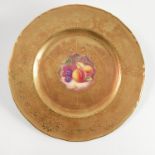 A Royal Worcester plate, the centre decorated with fruit to a mossy background by J Reed,