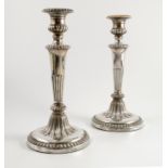 A pair of Georgian silver candlesticks, with gadrooned and fluted decoration,