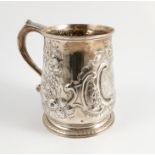 A Georgian silver pint mug, with embossed decoration and engraved with a crest, London 1735,