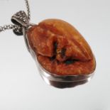 A large raw amber pendant, with Polish marks,